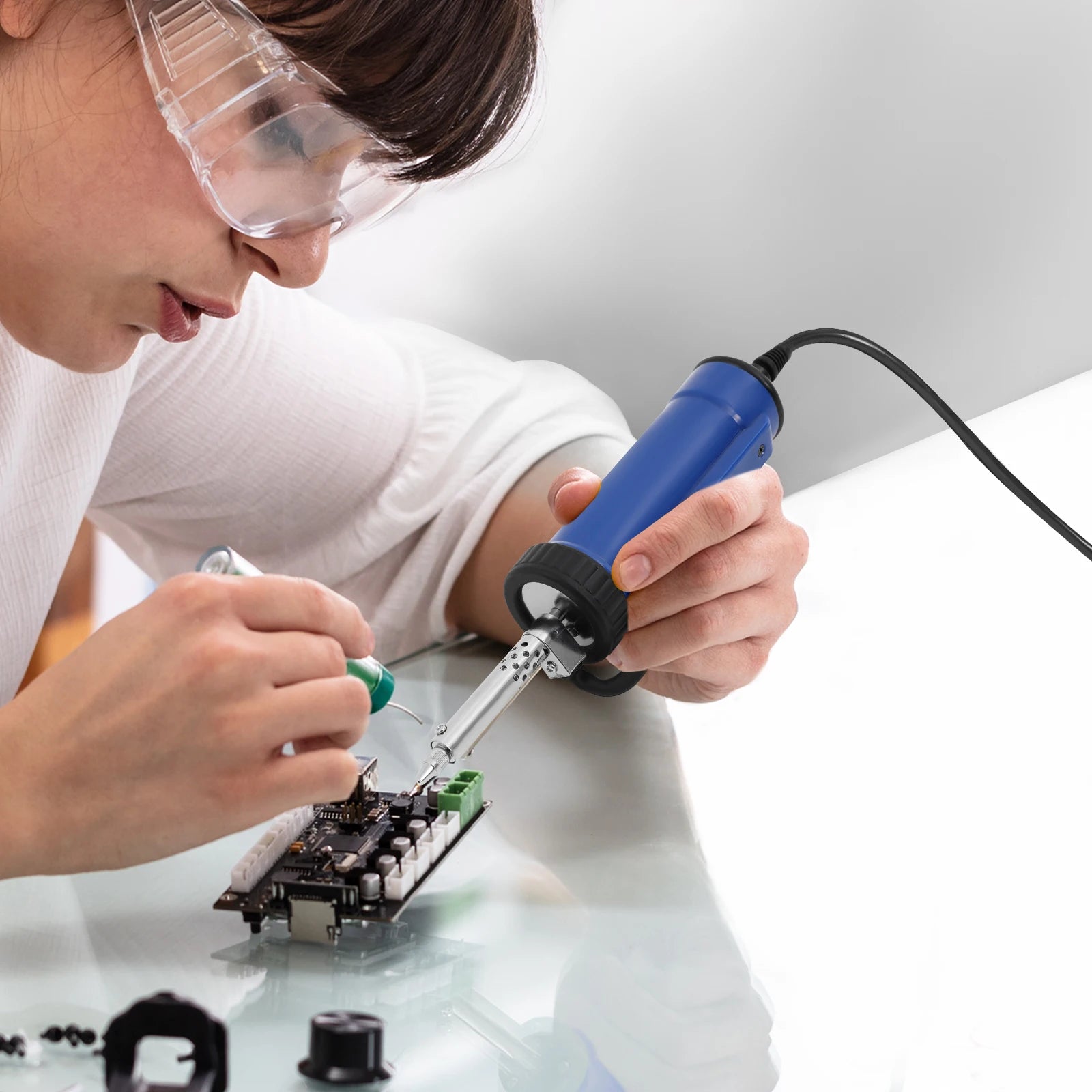 Utilisation de la pompe à dessouder sur un établi d'électronique